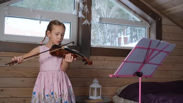 Little Girl Playing Violin and Exercising at Home