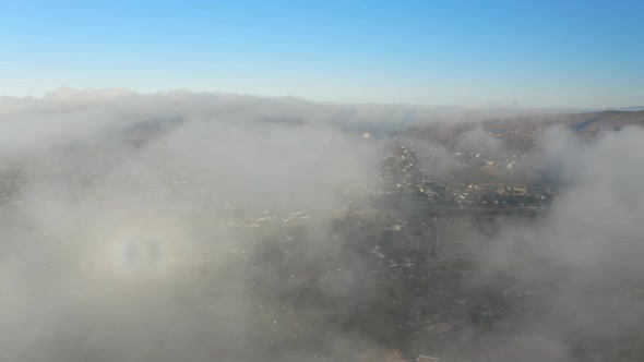 Aerial view of low fog over mountains in San Diego during sunrise