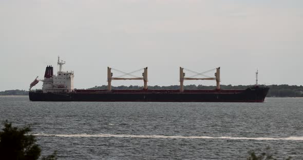 Large shipping container ship sails in harbor