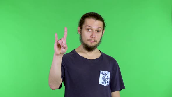 Portrait of a Young Man Who Makes the Devil Horn Symbol with His Fingers Rock Gesture