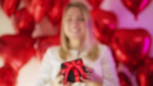 Portrait of Happy Blonde Woman Holding in Her Hands Black Velvet Gift Box