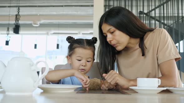 Young Woman Brunette and Toddler Daughter Choose Menu