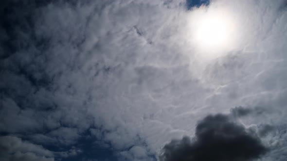 Clouds Move Smoothly in the Blue Sky on Background of Sun. Timelapse