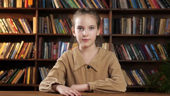 Serious Young Lady in Brown Jacket Looks Straight and Smiles