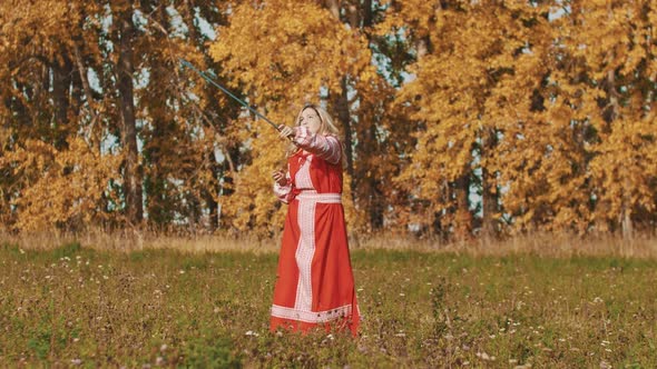 Medieval Concept - Woman in Red National Dress Rotating a Sword Around Herself