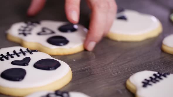 Step by step. Decorating sugar skull cookies with different color royal icing.