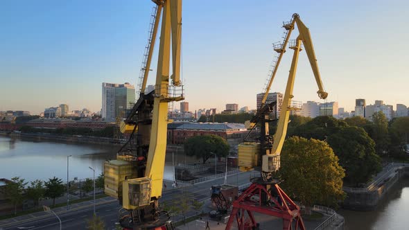 Aerial rising shot revealing two old port cranes in Puerto Madero docks, Buenos Aires