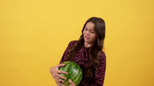 Confused Child Hold Heavy Water Melon on Yellow Background Watermelon