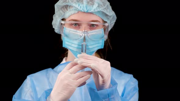 Professional Female Doctor Holds a Syringe with a Vaccine on a Black Background