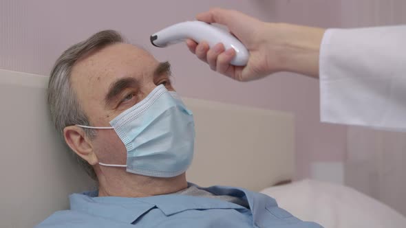 Sad Ill Elderly Man in Isolation at Home Wearing a Handmade Virus Protection Mask