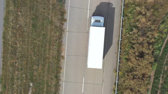 Aerial View of Truck with White Cargo Trailer Driving on Empty Road and Transporting Goods