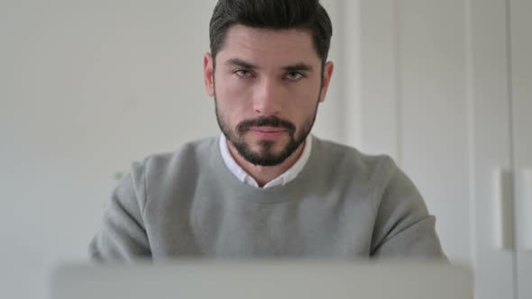 Close Up of Man Shaking Head As Yes Sign While Using Laptop