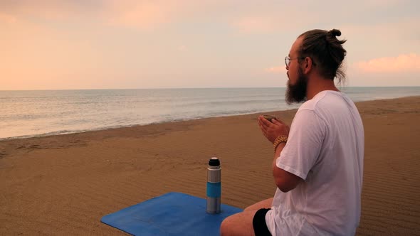 Man Drinks Tea at Beach