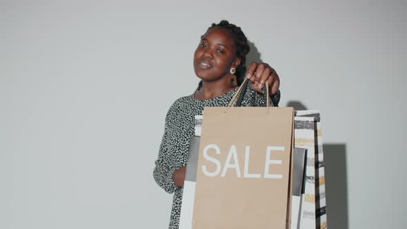 Happy Afro Woman Posing with Sale Shopping Bags