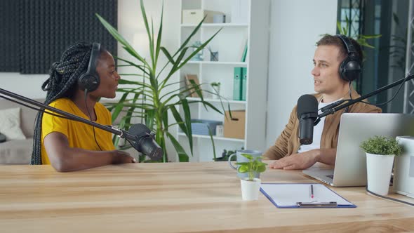 Female Host Talking to a Guest Friend on a Podcast Radio Station in the Studio