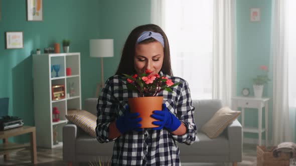 Portrait of Young Woman Smelling A Houseplant