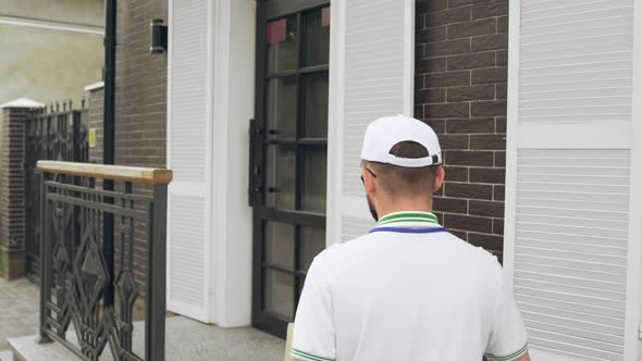 Young Male Courier Delivering Parcel.