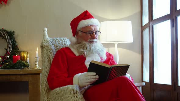 Santa claus looking through window while reading a novel