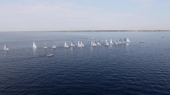 Sailing Yachts Lined Up in the Sea During a Sailing Regatta and Cast Shadows