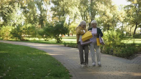 Elder Women Walking in Park, Showing and Boasting Purchases They Buy in Shop