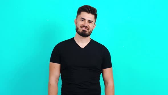 Young Caucasian Guy in a Black T-shirt Looking at the Camera with a Charming Smile.