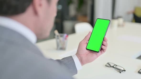 Businessman Looking at Smartphone with Green Chroma Key Screen