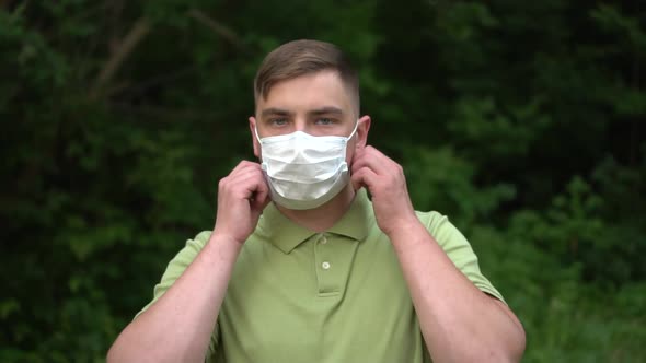 A Young Man Takes Off a Medical Mask and Throws It at the Camera
