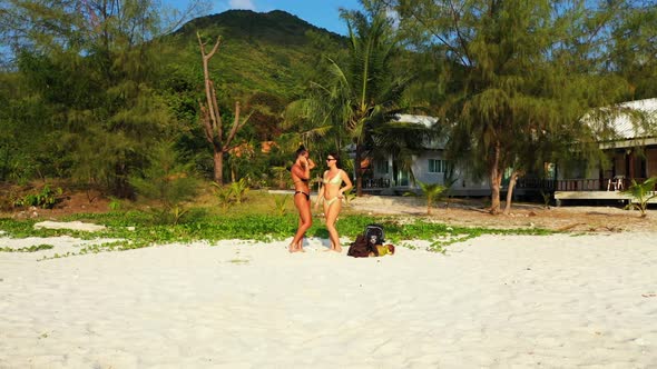 Ladies together relaxing on perfect shore beach time by blue ocean with white sandy background of Ko