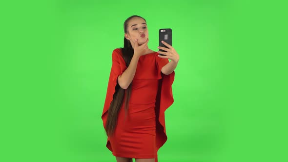 Pretty Young Woman Is Making Selfie on Mobile Phone Then Looking Photos. Green Screen