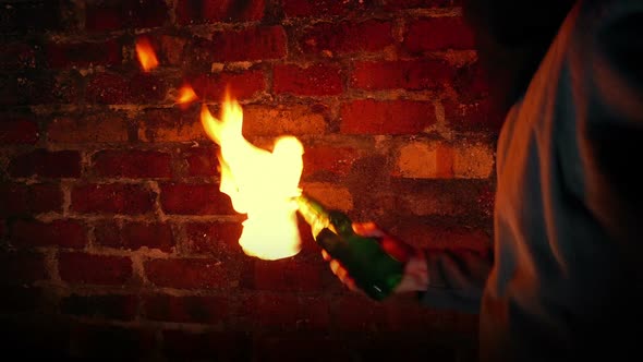 Anonymous Man Throws Molotov Cocktails By Brick Wall