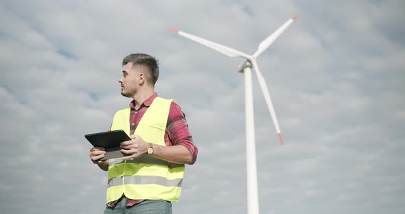 The Engineer with the Tablet in His Hand Performs the Work of the Windmill