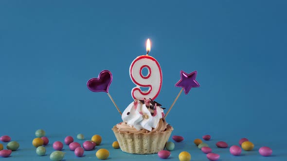Happy Birthday Greetings to 9 Year Old Child Birthday Cupcake with Candle and Birthday Decorations