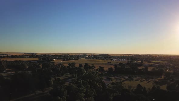 Aerial Drone view going up in little agricultural town during sunset, in Coronel Dorrego, Argentina