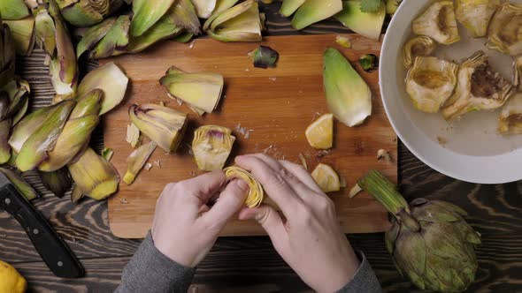 Woman Cleaning Heart of Artichokes with Spoon