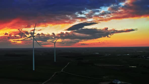 Beautiful aerial view of sunset with wind turbines on field