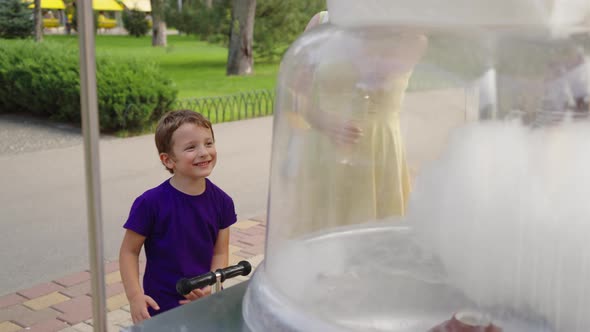 Boy Watching Cotton Candy Machine in Park