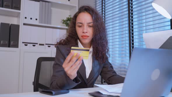 Depressed Latino business woman feel worried about financial problem in dark night at office.