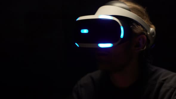 Portrait of Excited Young Man Wearing Modern Goggles and Interacting with Virtual Reality While