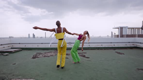 Models In Clubwear Dancing And Performing Together On Skyscraper