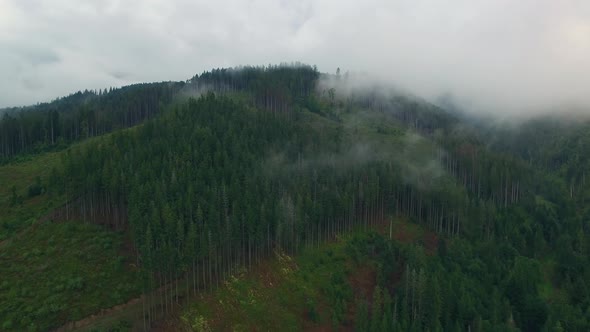 Aerial View. Flying over the high mountains in beautiful clouds . Aerial camera shot. Air clouds