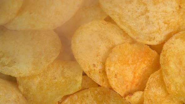Crispy hot potato chips with smoke rotating in macro. Golden fried potatoes close up. Potato snack