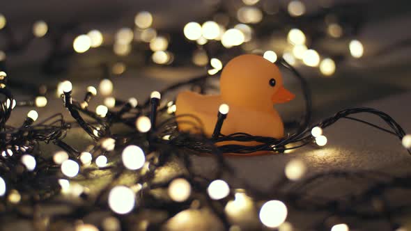 Closeup Shot of Rubber Duck on Background of Christmas Garland on a Playd