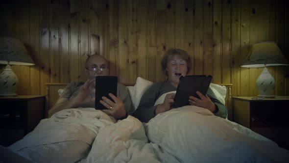 Senior Couple Reading In Bed