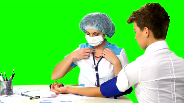 Doctor Taking Blood Pressure of Female Patient on Green Screen