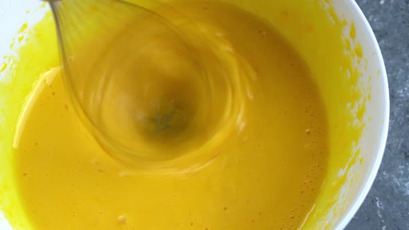 Close Up View on Blending Eggs and Sugar in White Ceramic Bowl with Mixer