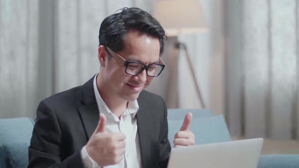 Asian Businessman In Jacket And Shorts Showing Thumbs Up Gesture While Having Video Call On A Laptop