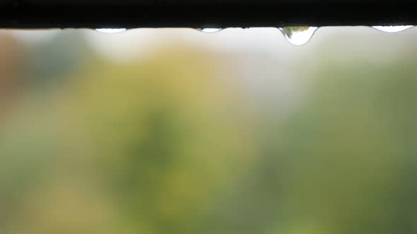 Transparent raindrops falling from the roof in front of shallow DOF 4K 2160p 30fps UltraHD video - E