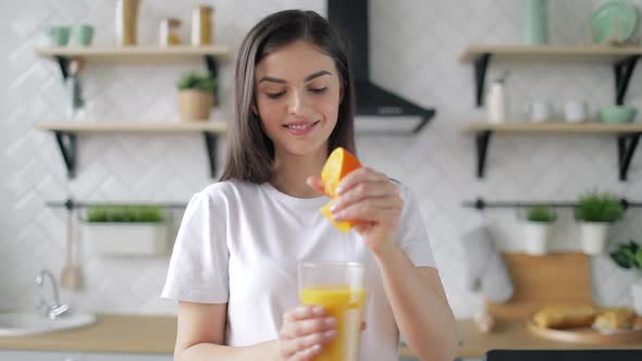 Woman Making Orange Juice in Kitchen