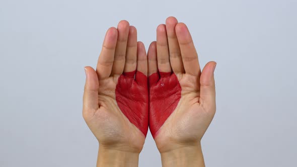 A woman joins two hands and two halves of her heart into one. Love, Valentine's Day, Mother's Day.