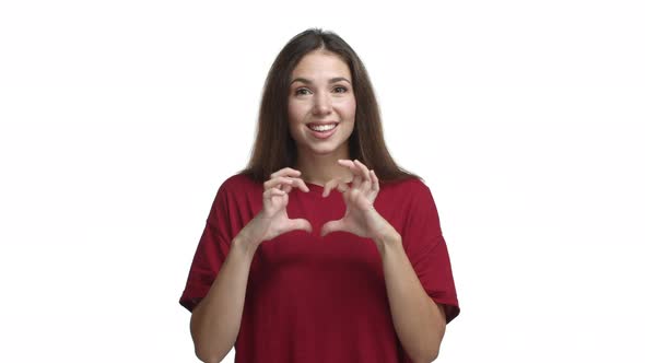 Pretty Brunette Girl Looking with Sympathy Making Love Sign in the Air and Saying I Love you